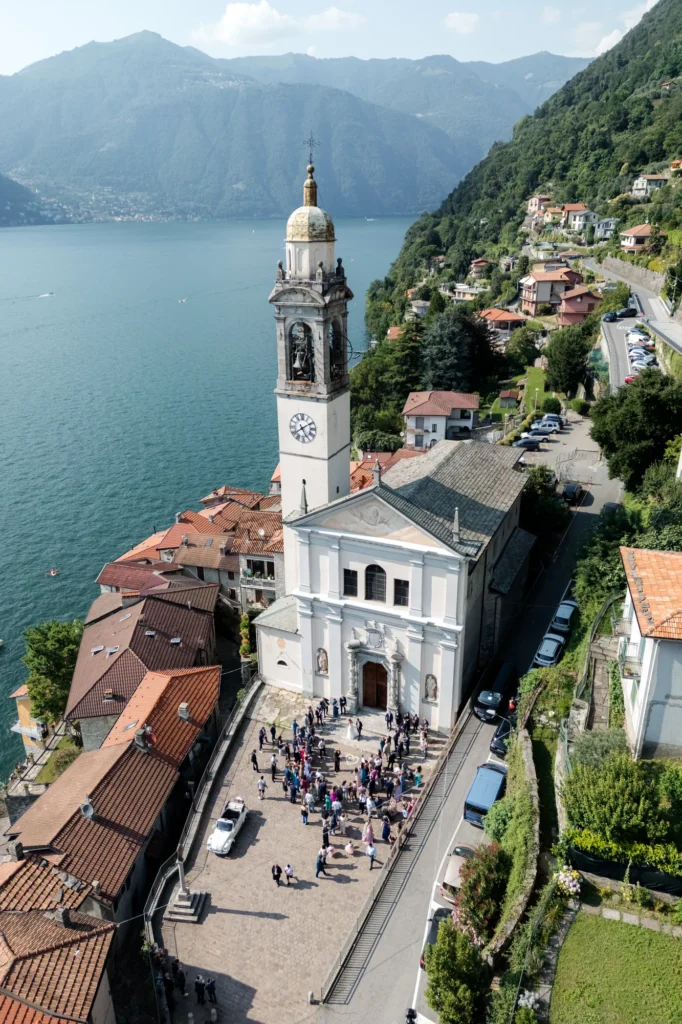 Guests outside a lakeside church, seen from above