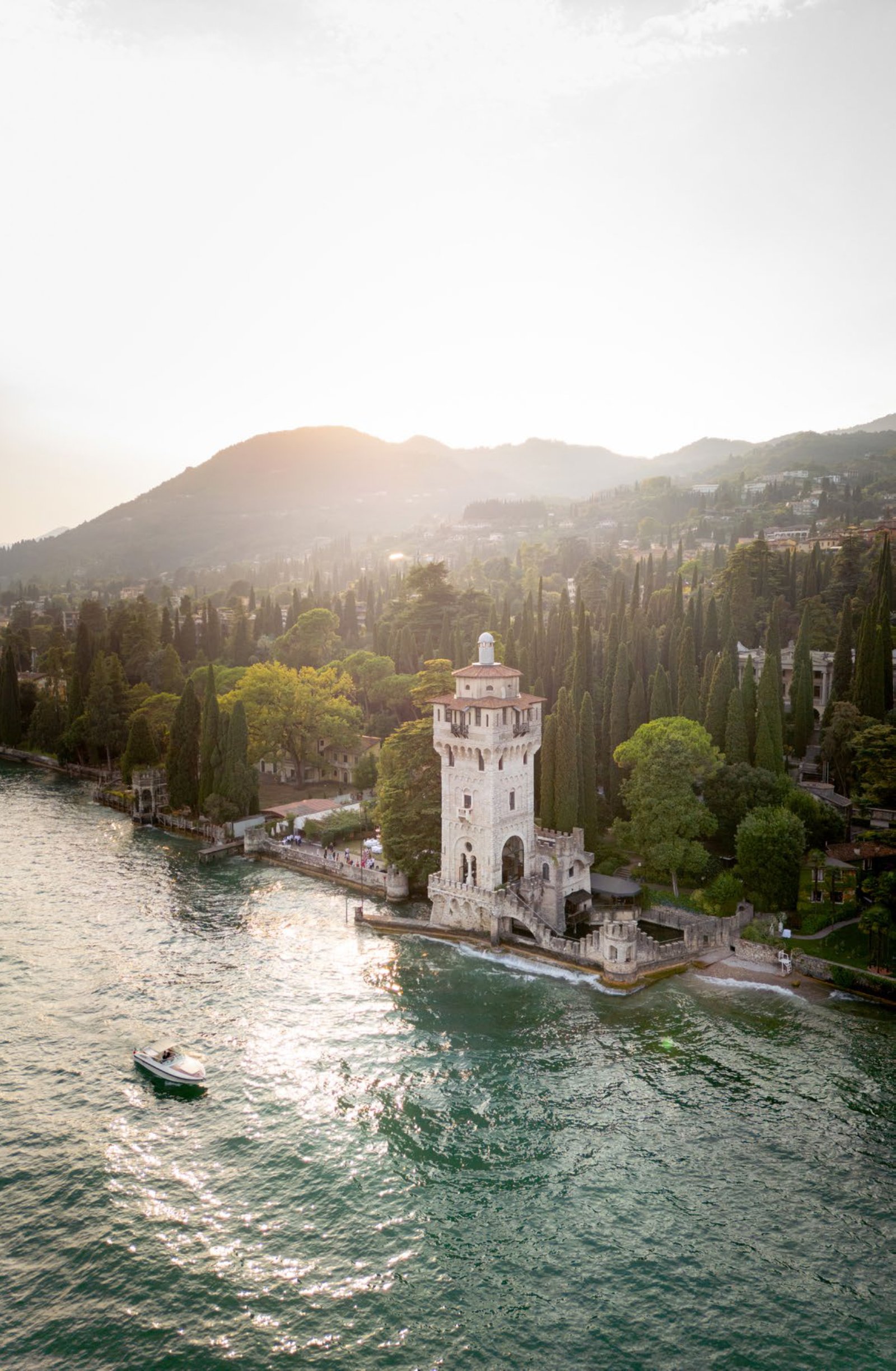 Villa sul lago tra le montagne al tramonto