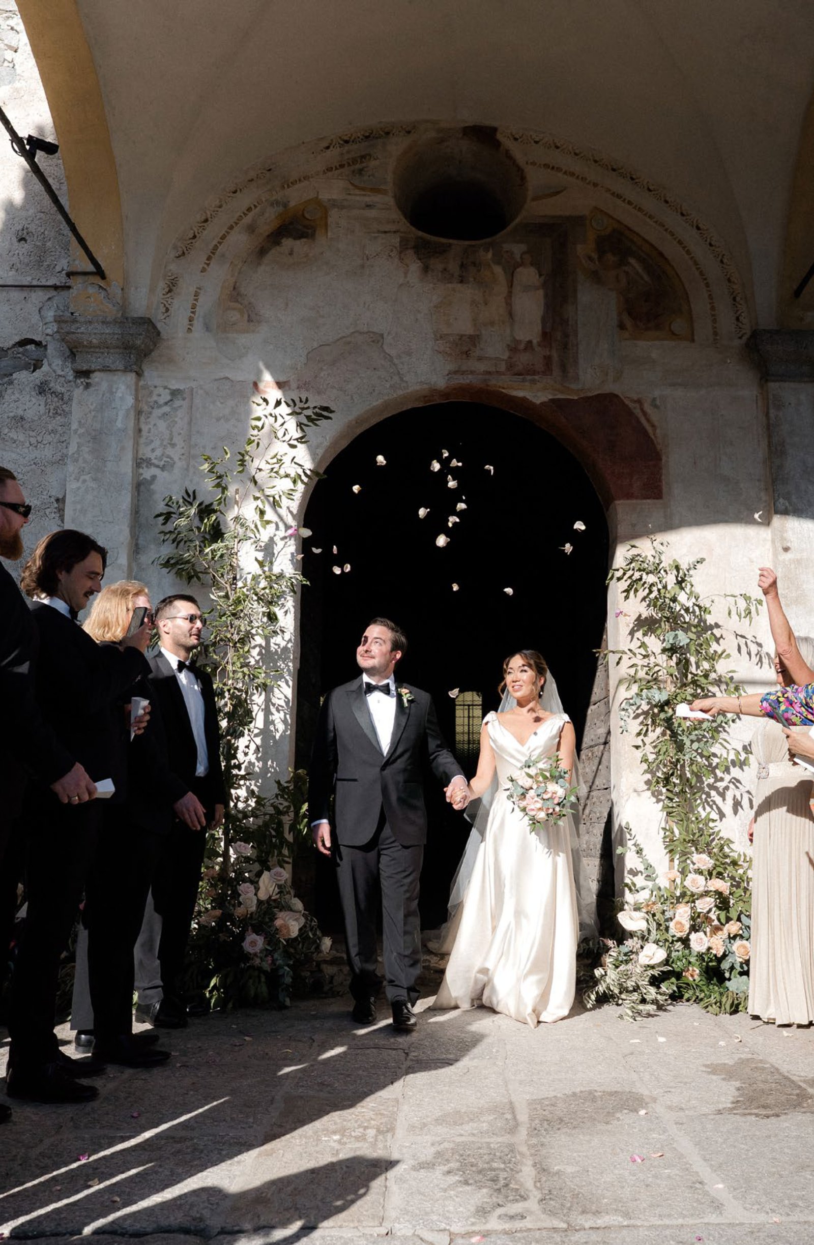 The couple walking out under the petals