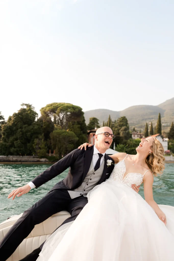 The couple laughing on a boat on Lake Garda